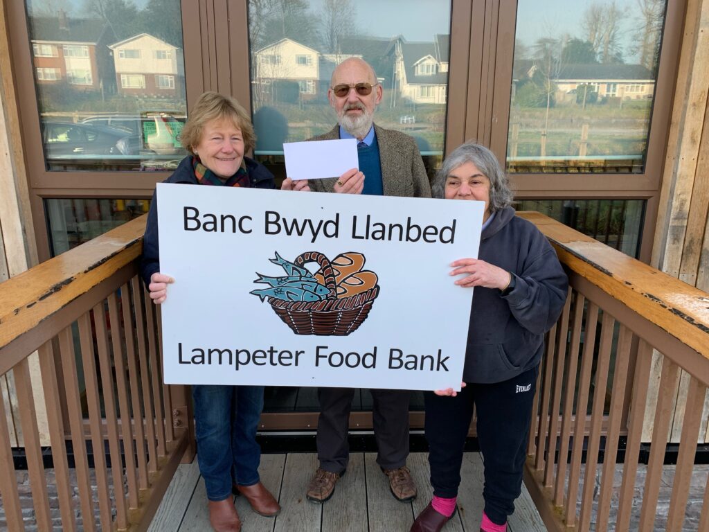 W Bro David Smith hands over a cheque to representatives of Lampeter Food Bank